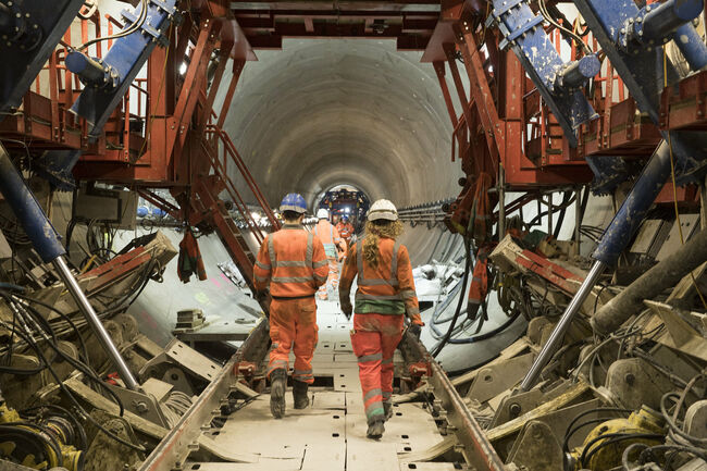 Two workers walk through a huge new sewer