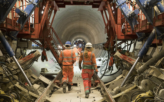 Two workers walk through a huge new sewer